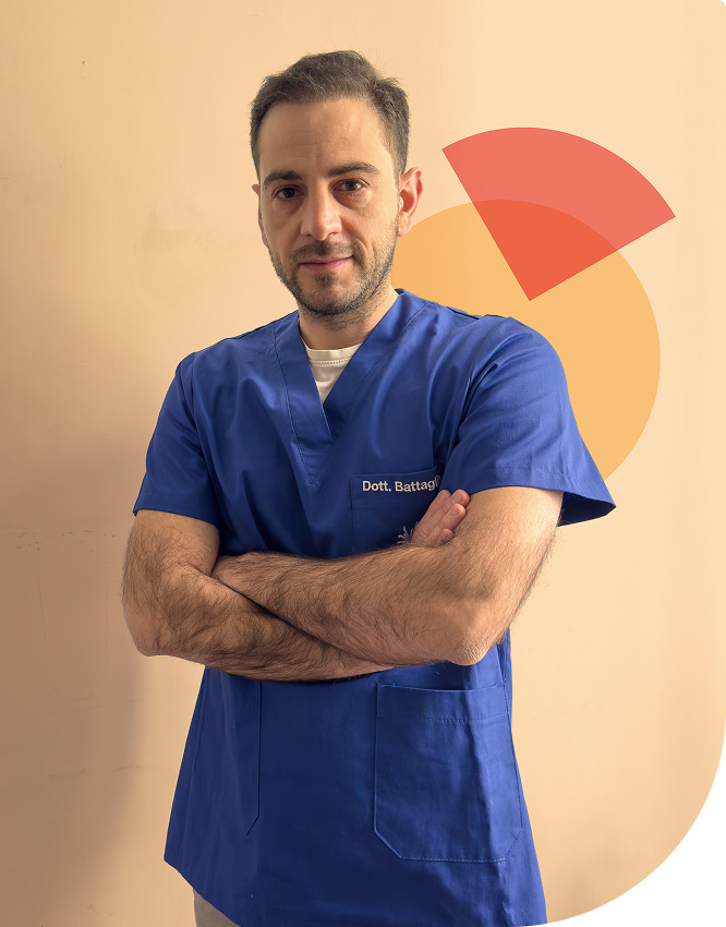 Il dottor Alberto Battaglini è a braccia incrociate, in piedi, sorridente.