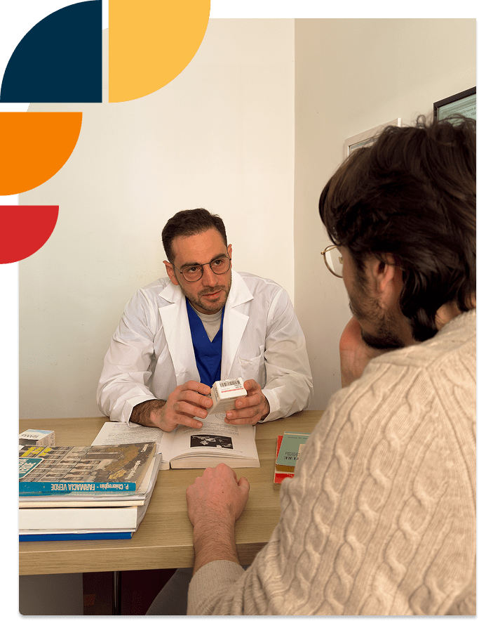 Il dottor Alberto Battaglini è alla scrivania e parla cordialmente con un paziente.